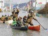 Japan Defense Force personell help people go through the flooded area