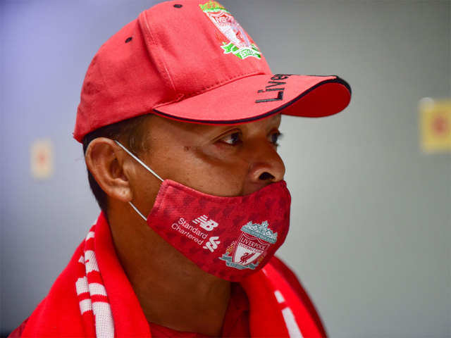 Liverpool fan wearing a face mask with the team's logo.
