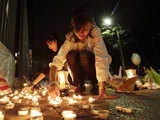 People light candles outside the Japanese embassy in Mexico