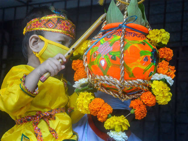 A child dressed as Lord Krishna tries to break an earthen pot (Dahi Handi) on the occasion of Krishna Janmashtami festival.