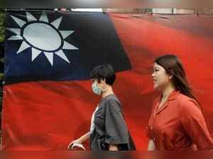 People walk past a Taiwan flag in Taipei