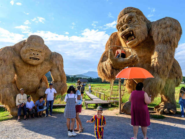 Tourists enjoy taking pictures with the giant straw sculptures