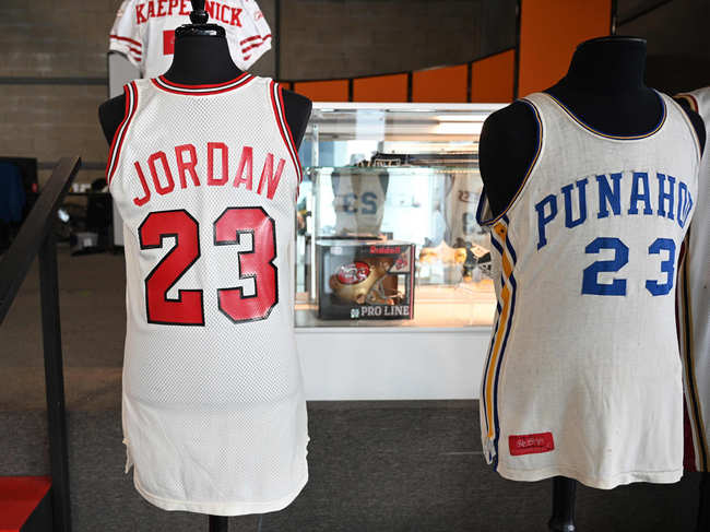 A Michael Jordan 1984 signing day Chicago Bulls official NBA game jersey is displayed beside the U.S. President Barack Obama's 1978-1979 game worn high school basketball jersey from Hawaii's Punahou School at a media preview of Julien's Auctions Presents Icons And Idols: Rock 'N' Roll, Hollywood and Sports, in Beverly Hills, California.