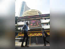 Mumbai: People walk in front of a digital screen at the facade of BSE, as the Se...