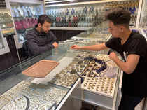 An employee shows a customer a gold ring at a jewellery shop in Misrata
