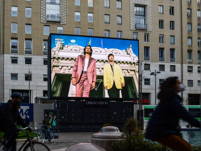 ​A screen displays a broadcast of the Fall/Winter 2021 Men's fashion collections by the Italian Chamber of Italian Fashion (Camera Nazionale della Moda Italiana ) on January 15, 2021, in downtown Milan, on the opening day of a four-day so-called 'phygital fashion week', a mix of digital and physical shows.