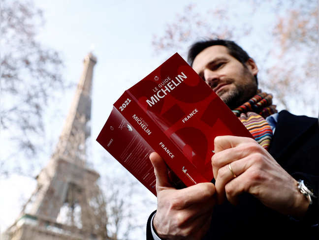 Gwendal Poullennec, International Director of Michelin Guides, poses holding a copy of the Michelin Guide 2021 before the ceremony to award stars to French restaurants, which have been closed for months due to restrictions against the spread of the coronavirus disease (COVID-19), in Paris