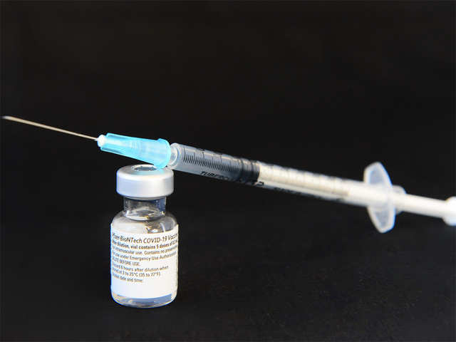 The Syringe with Long Needle and Medical Vial on Table. Black and