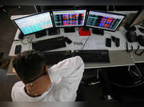 FILE PHOTO: A broker reacts while trading at his computer terminal at a stock brokerage firm in Mumbai