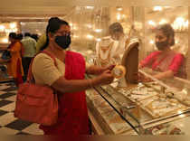 FILE PHOTO: Woman looks at a gold necklace at a jewellery showroom during Dhanteras in Kolkata