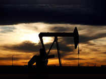 FILE PHOTO: The sun sets behind a crude oil pump jack on a drill pad in the Permian Basin in Loving County