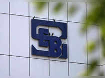 Birds rest on the logo of SEBI installed on the facade of its head office building in Mumbai