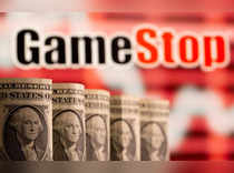 FILE PHOTO: U.S. one dollar banknotes are seen in front of displayed GameStop logo