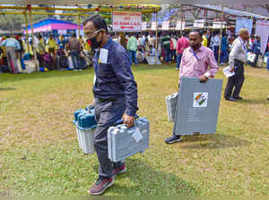Nagaon: Polling officials carry Electronic Voting Machines (EVMs) and other nece...