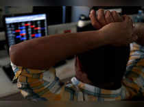 FILE PHOTO: Broker reacts while trading at his computer terminal at a stock brokerage firm in Mumbai