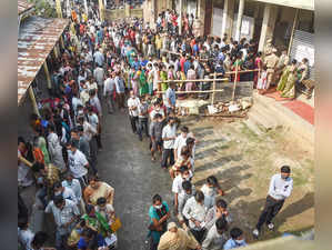 Guwahati: Citizens stand in a queue to cast their votes at a polling station, du...