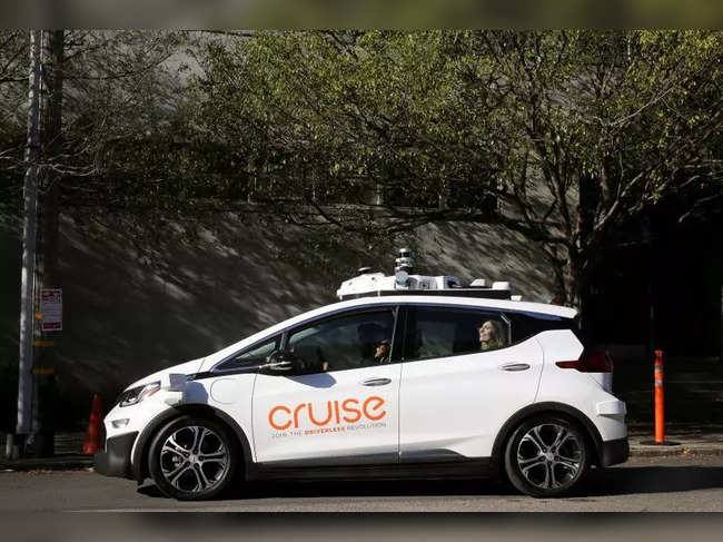 FILE PHOTO: A woman smiles in the back seat of a self-driving Chevy Bolt EV car during a media event by Cruise, GM's autonomous car unit, in San Francisco