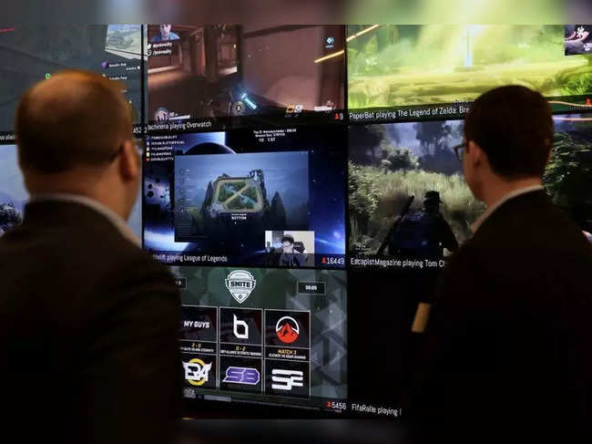 FILE PHOTO: Men look at a wall of real-time video game play in the lobby of Twitch Interactive Inc, a social video platform and gaming community owned by Amazon, in San Francisco, California