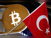 A bitcoin logo is seen next to Turkish flag at a cryptocurrency exchange shop in Istanbul