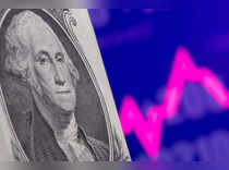 A U.S. one dollar banknote is seen in front of displayed stock graph in this illustration