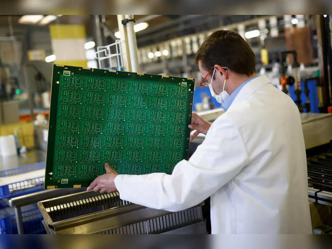 An employee of Atlantec Technologies works on printed circuit boards at the company's factory in Malville near Nantes