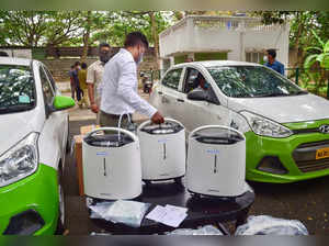 Bengaluru: An official keeps an oxygen concentrator inside an OLA taxi, to deliv...