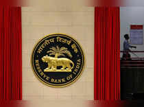 A worker walks past the logo of Reserve Bank of India inside its office in New Delhi