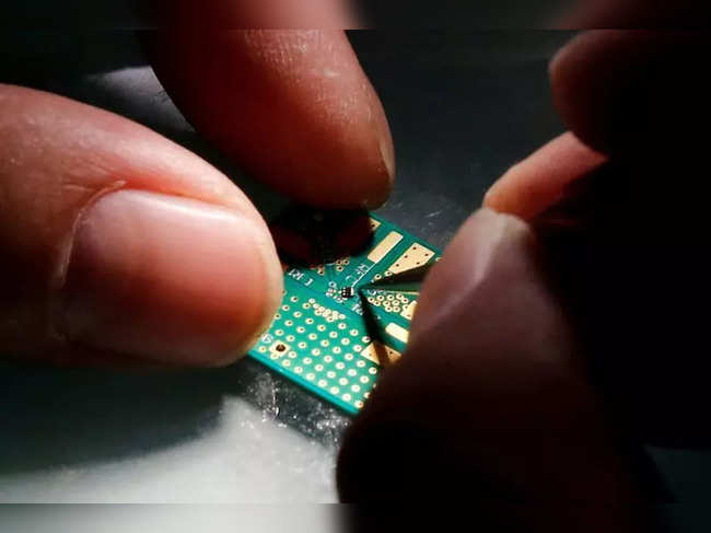A researcher plants a semiconductor on an interface board during a research work to design and develop a semiconductor product at Tsinghua Unigroup research centre in Beijing