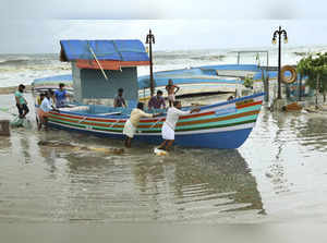 Kozhikode: People remove fishing boats from the seashore ahead of cyclone Taukta...