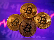 A representation of virtual currency Bitcoin is seen in front of a stock graph
