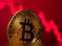 A representation of virtual currency Bitcoin is seen in front of a stock graph in this illustration