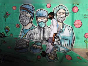 Boy walks past a graffiti in New Delhi