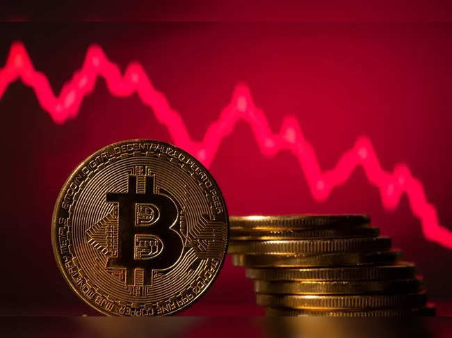 A representations of virtual currency Bitcoin is seen in front of a stock graph in this illustration
