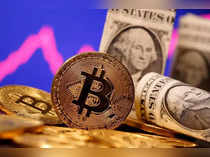 FILE PHOTO: A representation of virtual currency Bitcoin and U.S. One Dollar banknotes are seen in front of a stock graph in this illustration