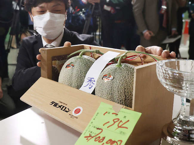 ​A man shows a pair of Yubari Melons which was sold for 2.7 million yen (about 25,000 USD) during the season's first auction at Sapporo Central Wholesale Market in Sapporo City.