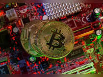 Representations of the virtual currency Bitcoin stand on a motherboard in this picture illustration