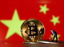 FILE PHOTO: Picture illustration of a small toy figurine and representations of the Bitcoin virtual currency displayed in front of an image of China's flag