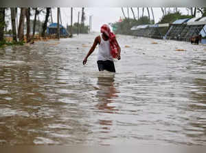 A man wades through a water-logged road after rains ahead of Cyclone Yaas at Digha
