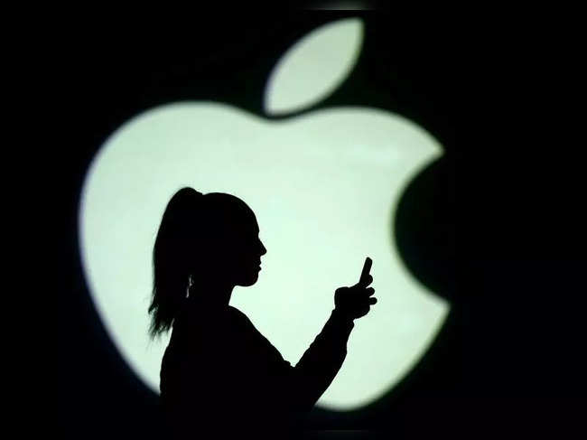FILE PHOTO: Picture illustration of a silhouette of a mobile user next to a screen projection of the Apple logo