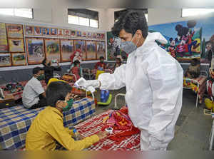 Sangli: A medic conducts thermal screening of a child admiited at a  COVID-19 ca...