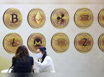 FILE PHOTO: Customers talk against a backboard with signs of cryptocurrency during 2020 Taipei International Finance Expo in Taipei,