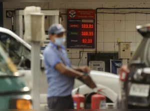 Mumbai: An attendant of a fuel station works as petrol prices cross the 100 rupe...