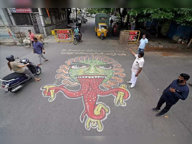 Bengaluru: Volunteers paint a road to create awareness against coronavirus, at C...