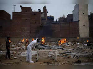 A man carries a body of a relative, who died from the coronavirus disease (COVID-19), at a crematorium in New Delhi,