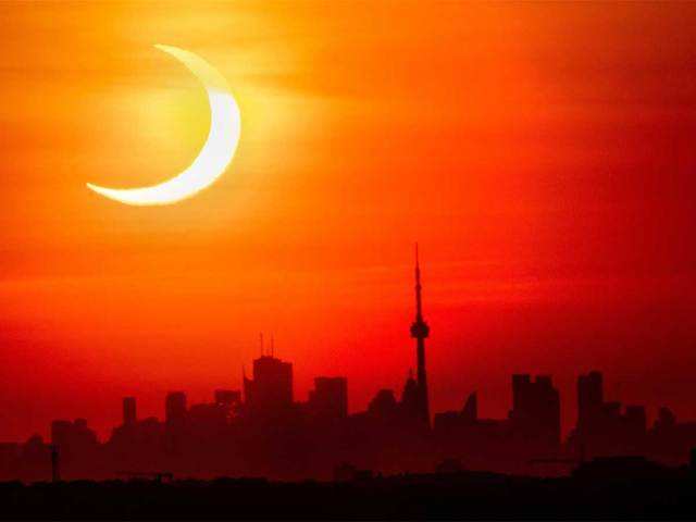 Solar eclipse rises over the skyline of Toronto