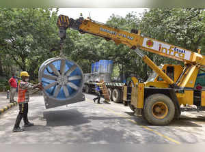 New Delhi: Workers unload a modified exhaust fan during construction of a 'smog ...