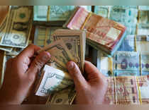 A man counts U.S. dollar banknotes at a currency exchange shop in Beirut