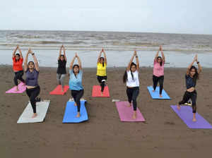 Surat: Women perform yoga on a beach ahead of International Yoga Day in Surat. (...