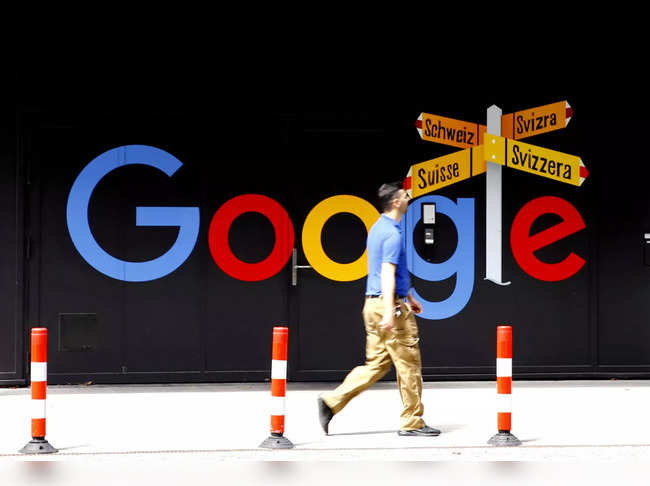 FILE PHOTO: A man walks past a logo of Google in Zurich