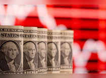 FILE PHOTO: U.S. one dollar banknotes are seen in front of displayed stock graph